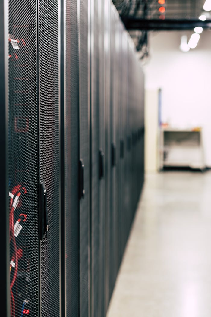 gallery-1 Metal black cabinets with servers inside with red wires connected standing in row in lighted room