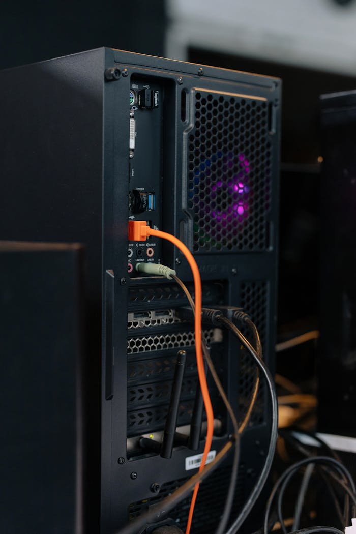 gallery-5 Close-up of a desktop computer tower with connected cables and internal lighting.